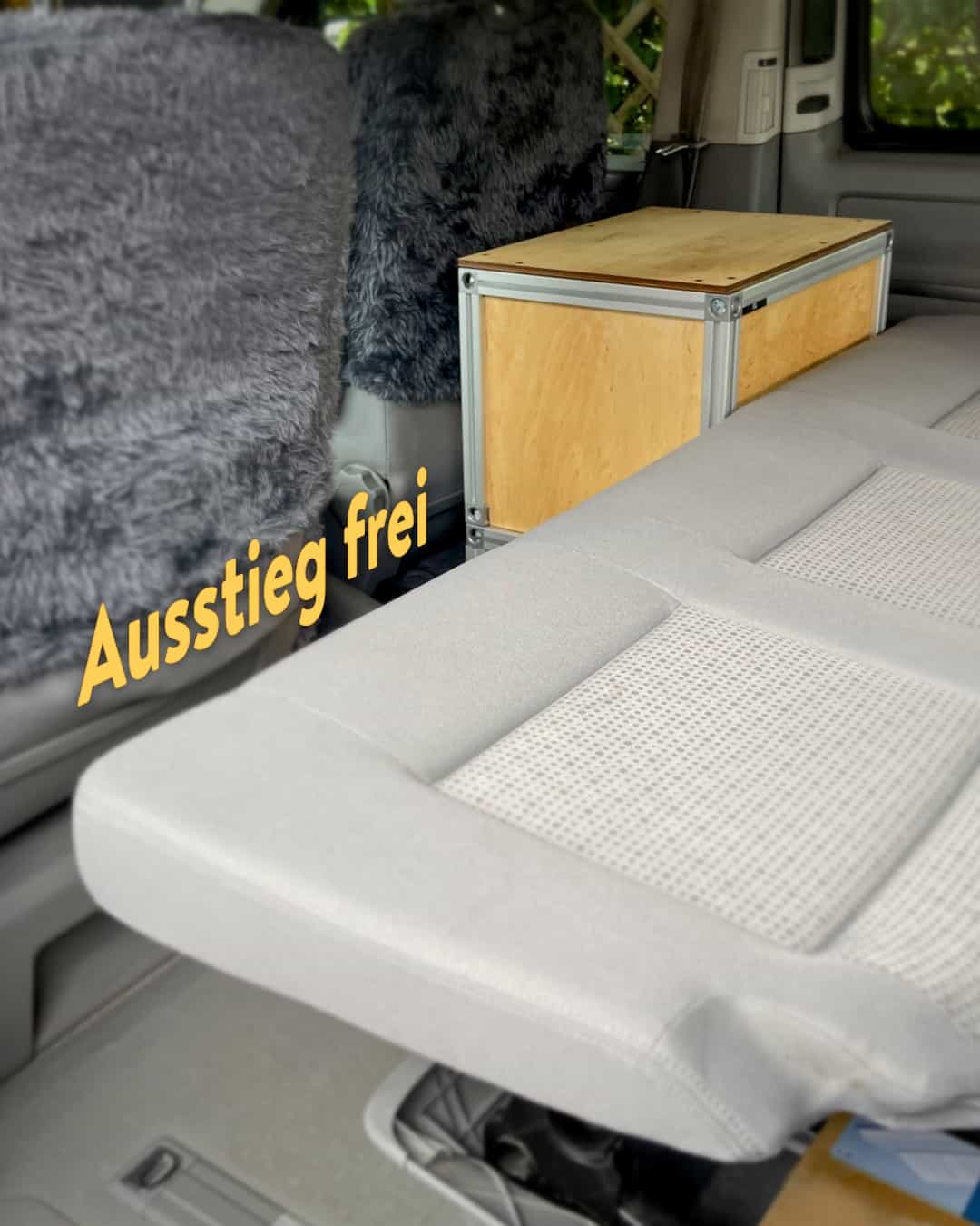 Ein Potti steht vor dem gebauten Bett im Minivan.