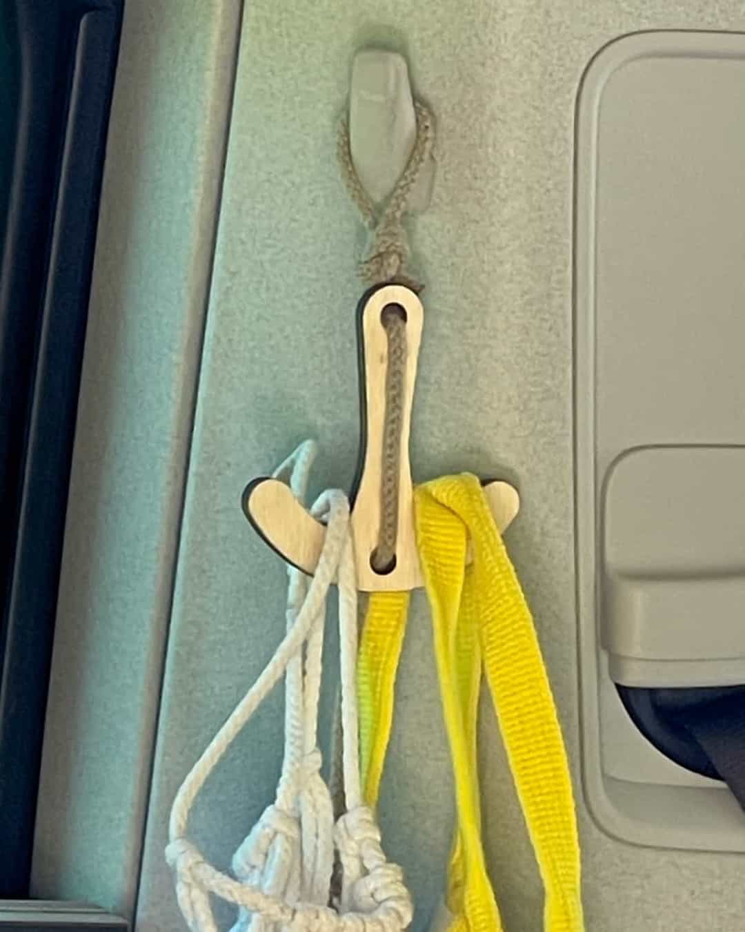 Am Kleiderhaken im Van hängt der Doppelhaken mit Makramee Netz und Einkaufstasche.